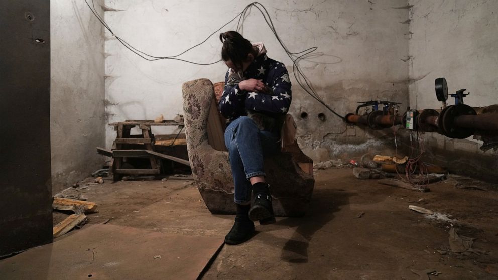 A woman holds her cat in a shelter during Russian shelling, in Mariupol, Ukraine, Thursday, Feb. 24, 2022. Russia has launched a barrage of air and missile strikes on Ukraine early Thursday and Ukrainian officials said that Russian troops have rolled