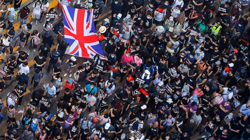 Protesters carry a British flag gather at a shopping district during a rally in Hong Kong, Sunday, Sept. 15, 2019. Thousands of Hong Kong people chanted slogans and marched Sunday at a downtown shopping district in defiance of a police ban, with shop
