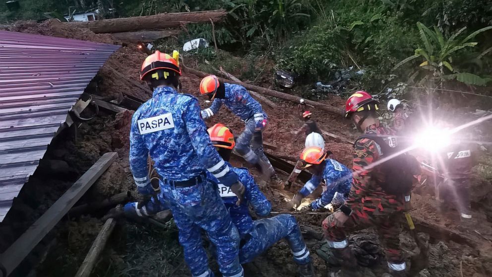 In this photo provided by Civil Defense Department, Civil Defense personnel search for survivors buried after a landslide hit a campsite in Batang Kali, Malaysia, Friday, Dec. 16, 2022. A landslide hit the campsite outside Kuala Lumpur early Friday, 
