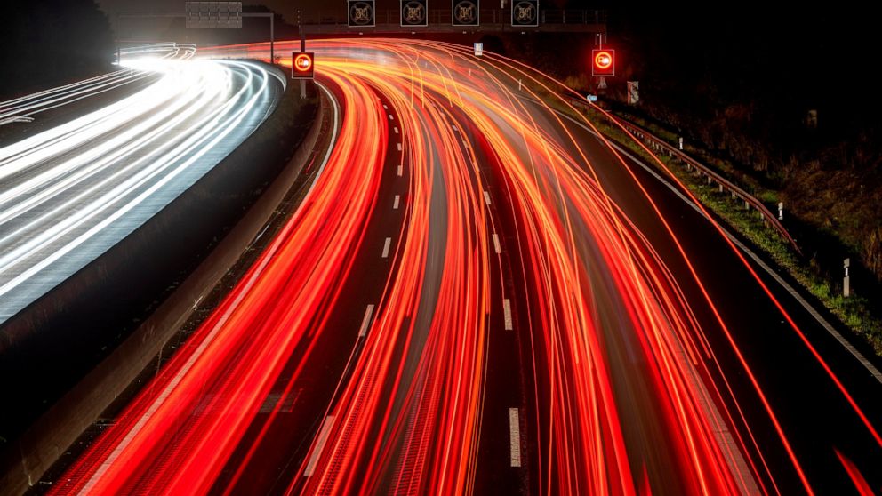 FILE -- This photograph taken with long exposure photo shows cars and trucks driving on a highway in Frankfurt, Germany, early Tuesday, Sept. 27, 2022. Officials said Monday that Germany is postponing politically sensitive decisions on reducing green
