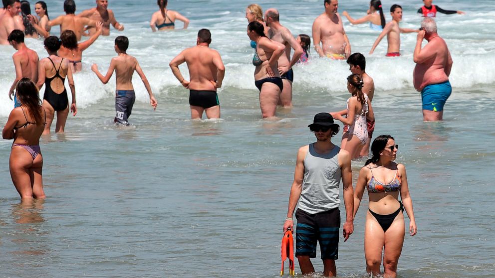 People enjoy the sea in Biarritz southwestern France, Wednesday, May 18, 2022. The hot weather is expected to last for several days across the country. (AP Photo/Bob Edme)