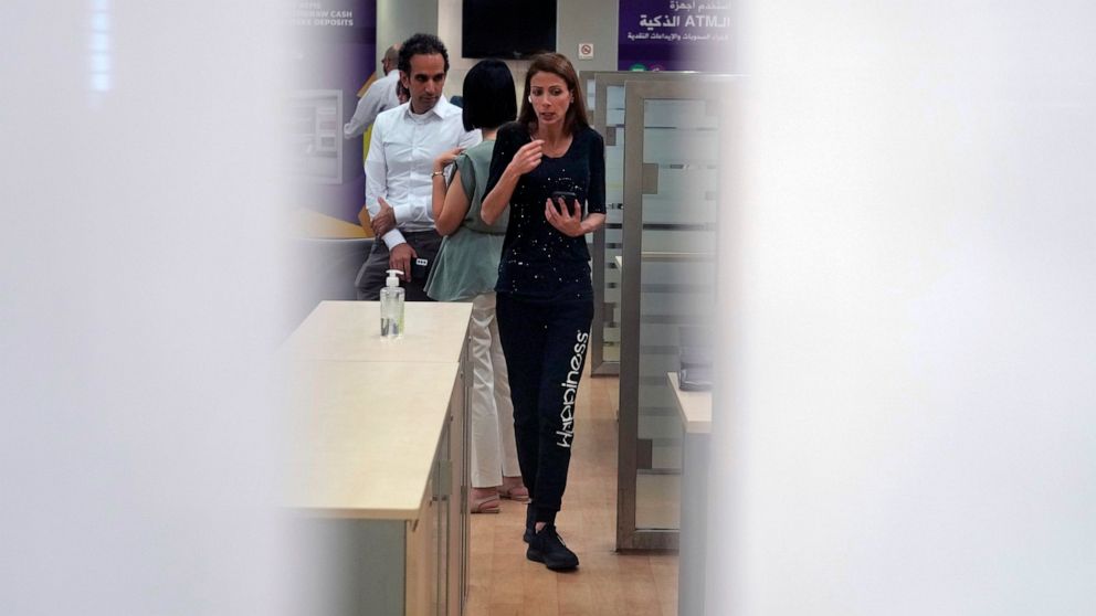 Beirut legislator Cynthia Zarazir speaks on the phone as she walks inside a Byblos Bank branch near the capital Beirut, demanding some of her trapped savings to cover medical expenses, in Antelias, Lebanon, Wednesday, Oct. 5, 2022. Cash-strapped Leba
