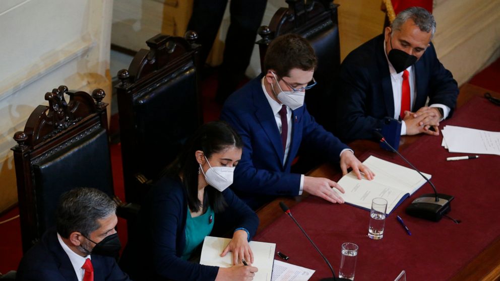 Leaders of the Constitutional Convention, Maria Elisa Quinteros, second from left, and Gaspar Dominguez, third from left, attend a ceremony to deliver the final draft of a proposed, new constitution inside the former Congress in Santiago, Chile, Mond