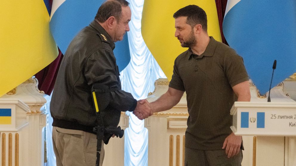 Ukrainian President Volodymyr Zelenskyy, right, and Guatemalan President Alejandro Giammattei shake hands during a news conference after their meeting in Kyiv, Ukraine, Monday, July 25, 2022. (AP Photo/Efrem Lukatsky)