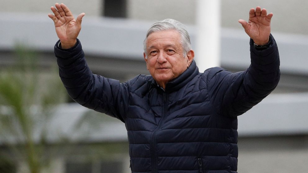 FILE - In this April 3, 2020 file photo, Mexican President Andres Manuel Lopez Obrador waves to supporters at the end of a visit to a Social Security Institute hospital that will be converted to receive patients infected with the new coronavirus, in 