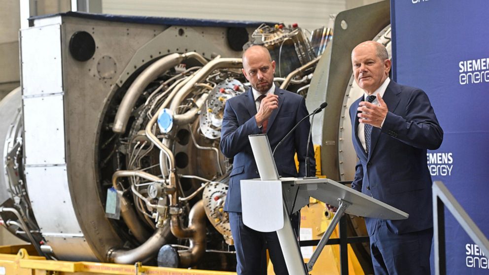 German Chancellor Olaf Scholz, right, stands besides Christian Bruch, CEO of Siemens Energy, at the turbine serviced in Canada for the Nordstream 1 natural gas pipeline in Muelheim an der Ruhr, Germany, Aug. 3, 2022. German Chancellor Olaf Scholz vis