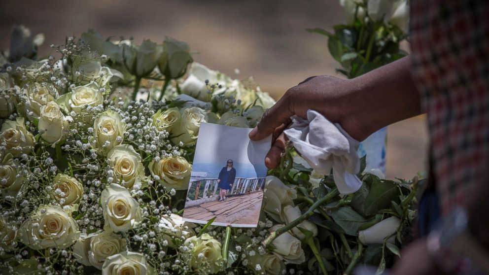 A family member puts a photo on flowers at the scene where the Ethiopian Airlines Boeing 737 Max 8 plane crashed shortly after takeoff on Sunday killing all 157 on board, near Bishoftu, south of Addis Ababa, in Ethiopia Wednesday, March 13, 2019. The