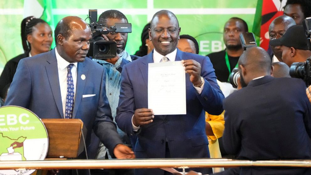 William Ruto, center, shows a certificate after the announcement of the results of the presidential race at the Centre in Bomas, Nairobi, Kenya, Monday, Aug. 15, 2022. After last-minute chaos that could foreshadow a court challenge, Kenya’s electoral