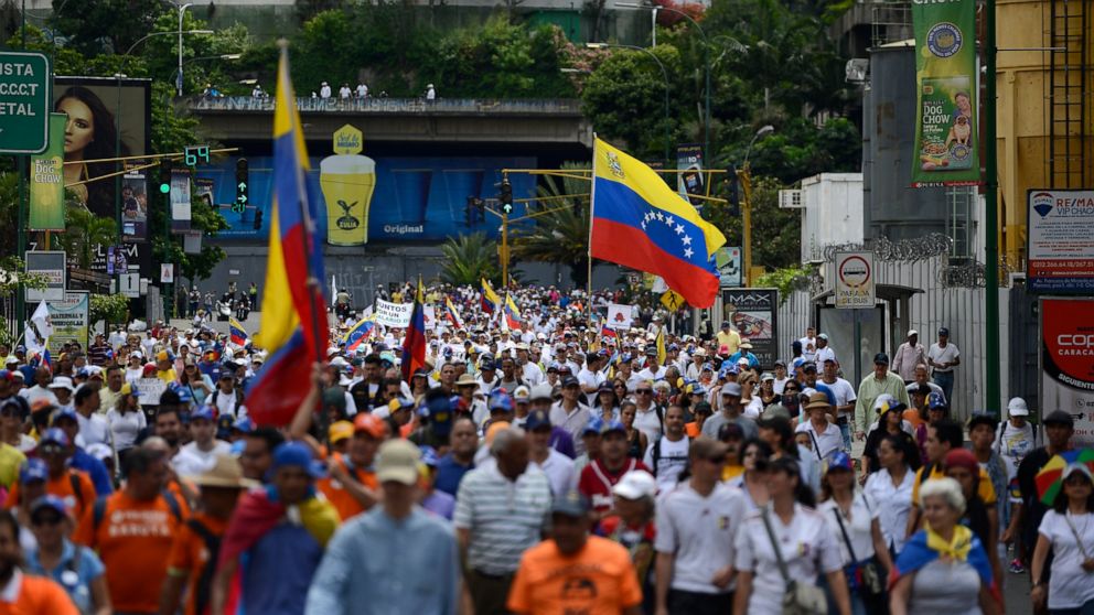 A crowd carrying flags and blowing whistles gather in a demonstration led by opposition politician Juan Guaido, who’s urging masses into the streets to force President Nicolás Maduro from power, in Caracas, Venezuela, Saturday, Nov. 16, 2019. Guaido 