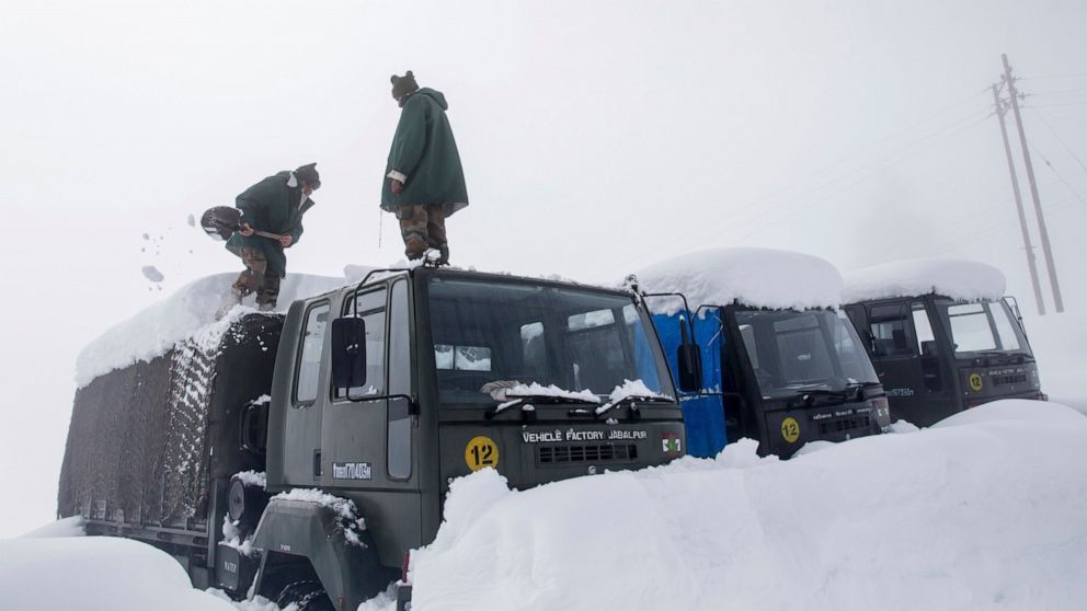 FILE - Indian Army soldiers clear snow from their stranded vehicles near a base camp in Gulmarg, about 55 kilometres (34 miles) northwest of Srinagar, Indian controlled Kashmir, Friday, Jan. 27, 2017. An avalanche in Kashmir has killed three Indian s