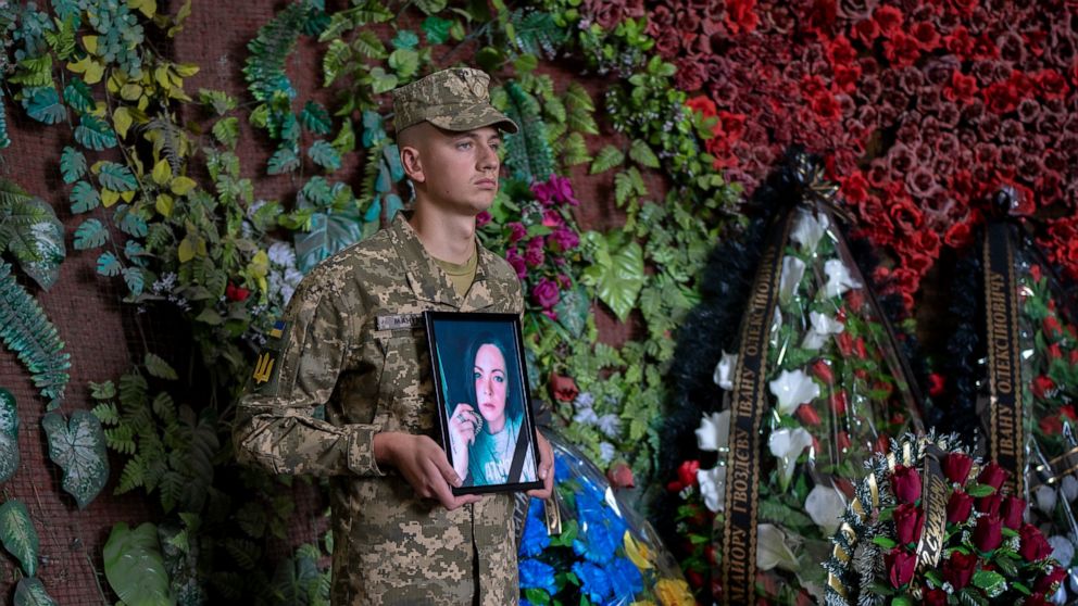 A Ukrainian soldier holds a photo of Olga Simonova, 34, a Russian woman who was killed in the Donetsk region while fighting on Ukraine's side in the war with her native country, in a crematorium in Kyiv, Ukraine, Friday, Sept. 16, 2022. (AP Photo/Rom