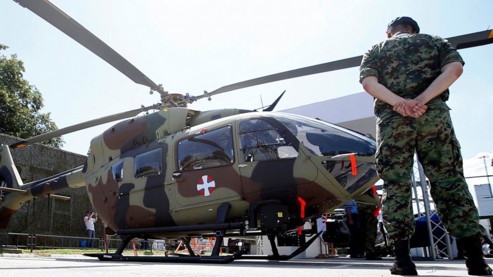 FILE - A Serbian Army officer stands by new Airbus H145M multi-utility helicopter during an arms fair in Belgrade, Serbia, Tuesday, June 25, 2019. Cyprus signed a deal with Airbus Helicopters on Friday, June 24, 2022 to purchase six light attack heli