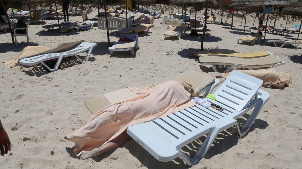 FILE - In this Friday, June 26, 2015 file photo, covered bodies lie on a beach in Sousse, Tunisia. More than 30 people have been summoned to face trial over the Tunisia's deadliest attack in a Mediterranean resort. The trial is scheduled to reopen on