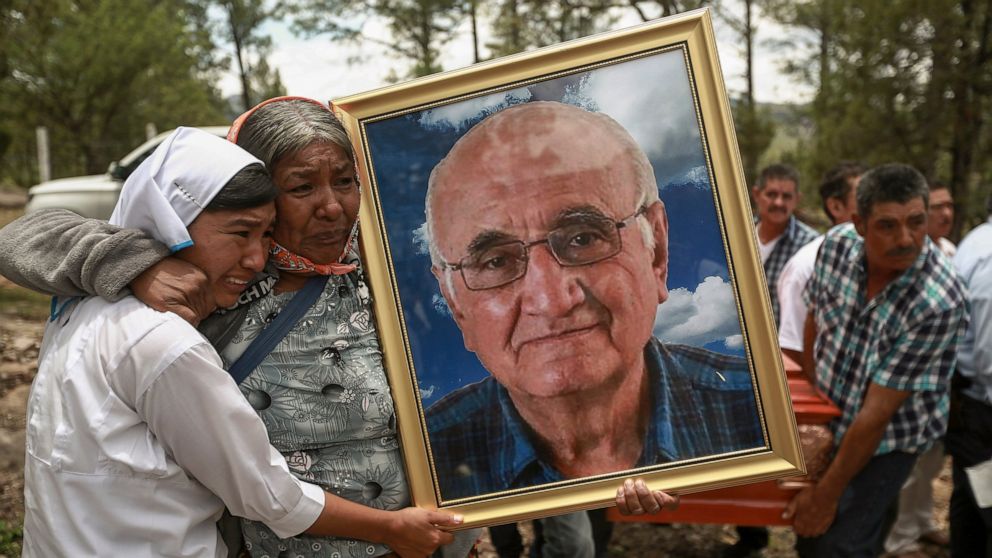 Women hold a portrait of Jesuit priest Javier Campos Morales as the funeral procession of Morales and fellow priest Joaquin Cesar Mora Salazar arrives to Cerocahui, Chihuahua state, Mexico, Sunday, June 26, 2022. The two elderly priests and a tour gu