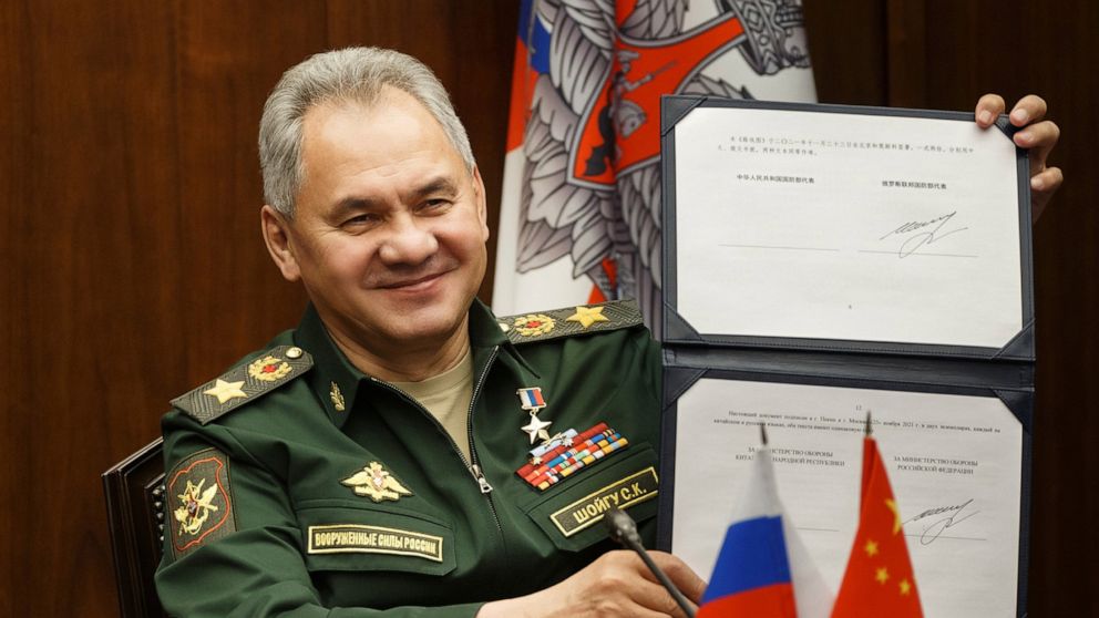 In this photo released by the Russian Defense Ministry Press Service, Russian Defense Minister Sergei Shoigu shows his signature under a roadmap for military cooperation between Russia and China during a video call with Chinese Defense Minister Wei F