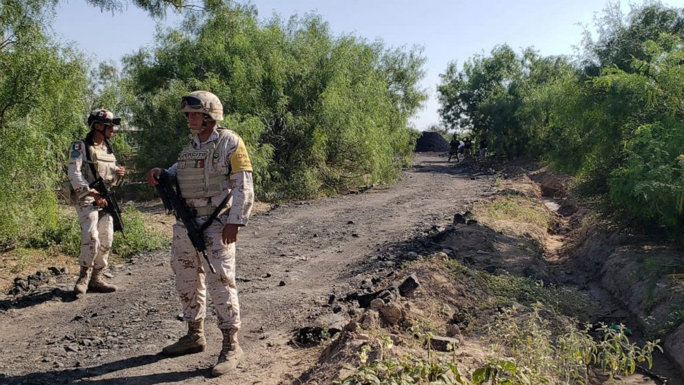 National Guards stand along the road that leads to where miners are trapped in a collapsed and flooded coal mine in Sabinas in Mexico's Coahuila state, Thursday, Aug. 4, 2022. The collapse occurred on 10 miners after they breached a neighboring area 