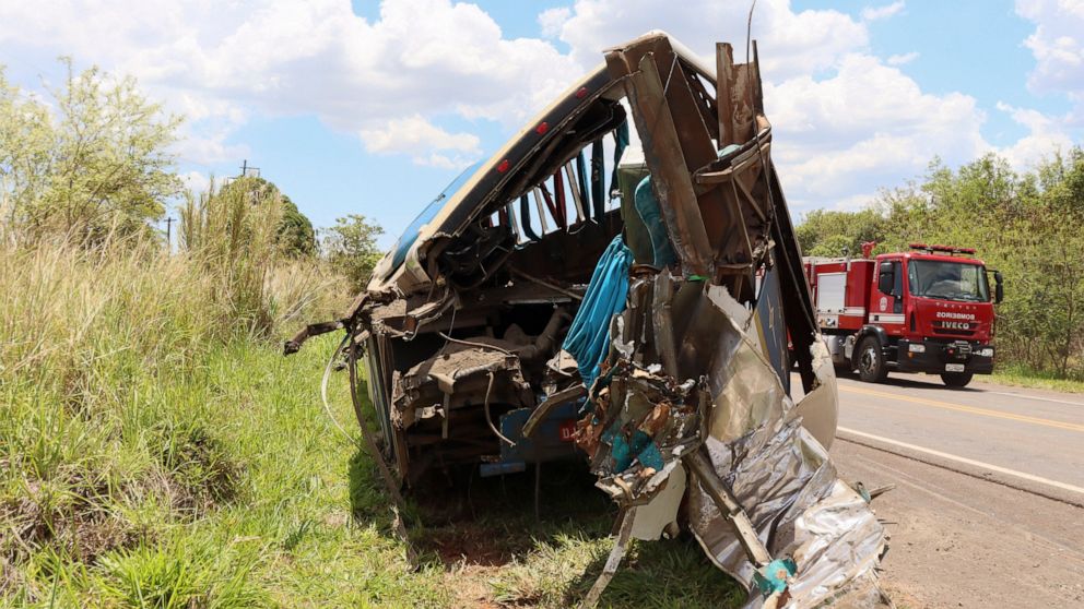 The wreckage of a bus that was carrying employees of a textile company remains on the shoulder of a road in the municipality of Taguai, about 350 kilometers (217 miles) from the city of Sao Paulo, Brazil, Wednesday, Nov. 25, 2020. The bus collided wi