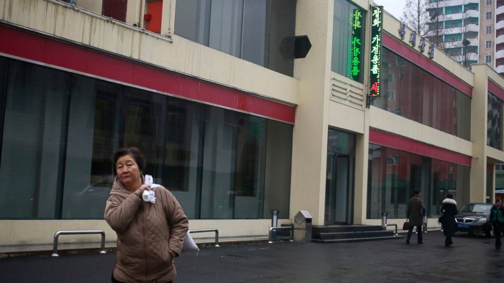 In this Dec. 21, 2018, photo, a North Korean woman walks outside Bugsae Shop, also known as the "Singapore Shop," in Pyongyang, North Korea. Despite the unwanted publicity of a criminal trial for one of their main suppliers, business is booming at Py