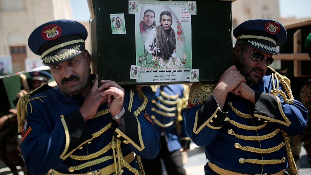 FILE - In this Feb. 16, 2021 file photo, honor guards carry coffins adorned with photographs of Houthi rebel fighters who who were killed in recent fighting with forces of Yemen's Saudi-backed internationally recognized government during their funera