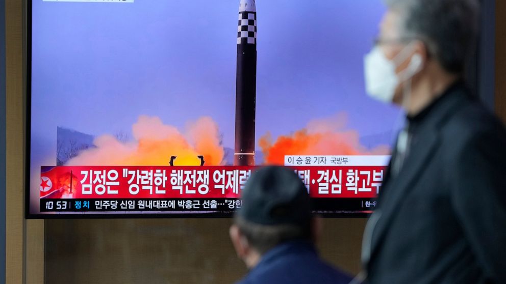 People watch a TV screen showing a news program reporting about North Korea's ICBM at a train station in Seoul, South Korea, Friday, March 25, 2022. North Korea said Friday it test-fired its biggest-yet intercontinental ballistic missile under the or