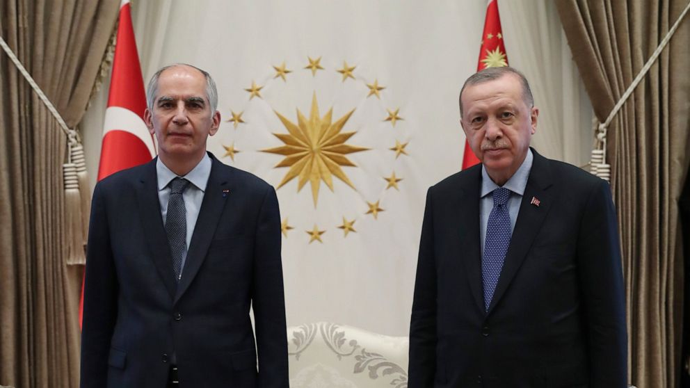 FILE - In this Aug. 19, 2020 file photo, Frence ambassador to Turkey Herve Magro, left, and Turkey's President Recep Tayyip Erdogan pose for photographs after the new ambassador presented his letter of credentials, in Ankara, Turkey. France recalled 