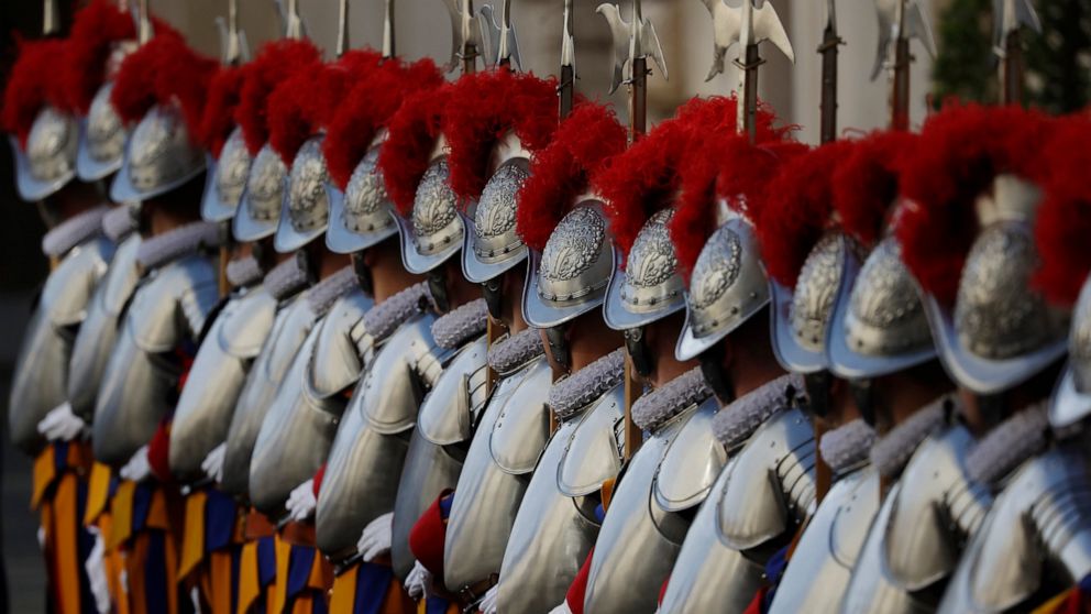FILE - In this Thursday, May 6, 2021 file photo, Vatican Swiss Guards stand attention at the St. Damaso courtyard on the occasion of their swearing-in ceremony, at the Vatican. The Swiss government has decided to set up a dedicated embassy to the Vat