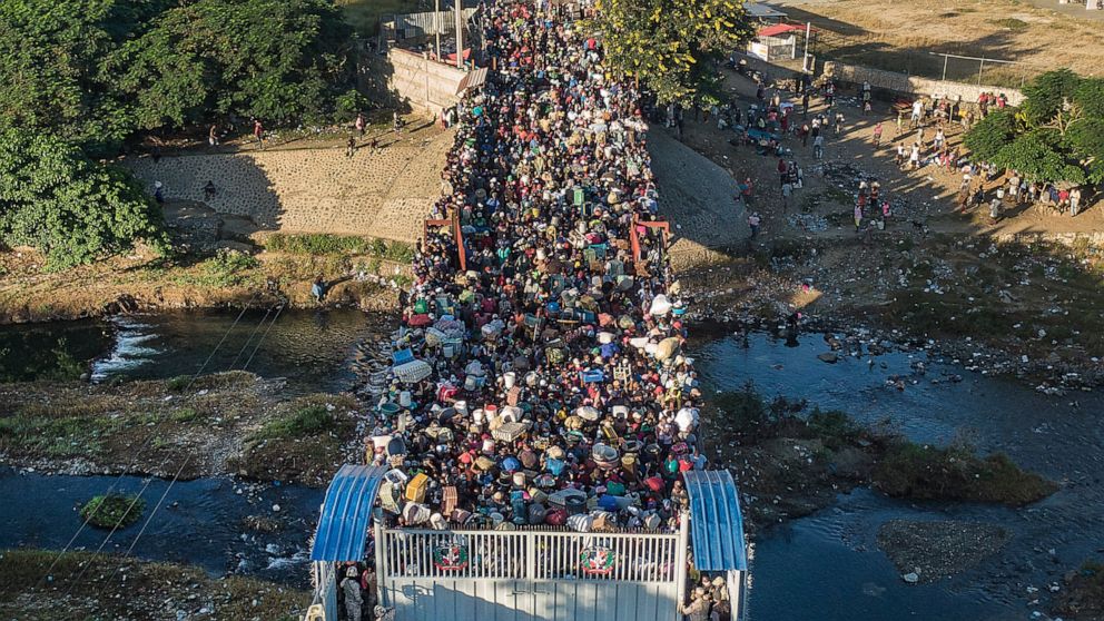 FILE - Haitians wait to cross the border between Dominican Republic and Haiti in Dajabon, Dominican Republic, Friday, Nov. 19, 2021. The Dominican Republic said on Sunday, Nov. 21, 2022 that it “profusely rejects” the denunciation of its migratory cr