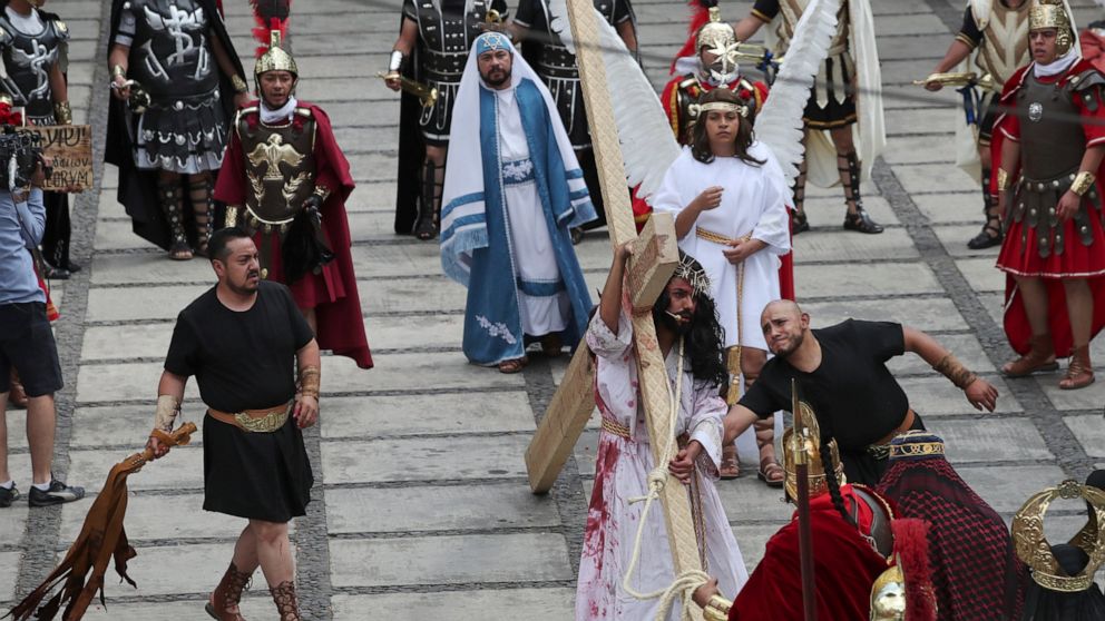 Residents reenact the crucifixion of Jesus Christ in the Passion Play of Iztapalapa, outside the Cathedral, on the outskirts of Mexico City, Friday, April 2, 2021, amid the new coronavirus pandemic. To help prevent the spread of the COVID-19, Latin A