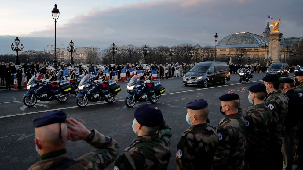 French soldiers stand in an honour guard on Thursday Jan.7, 2021 as the hearse convoy of late French forces soldiers rides on the Alexandre III bridge in central Paris. A ceremony was held to pay homage to two soldiers killed in Mali by an improvised