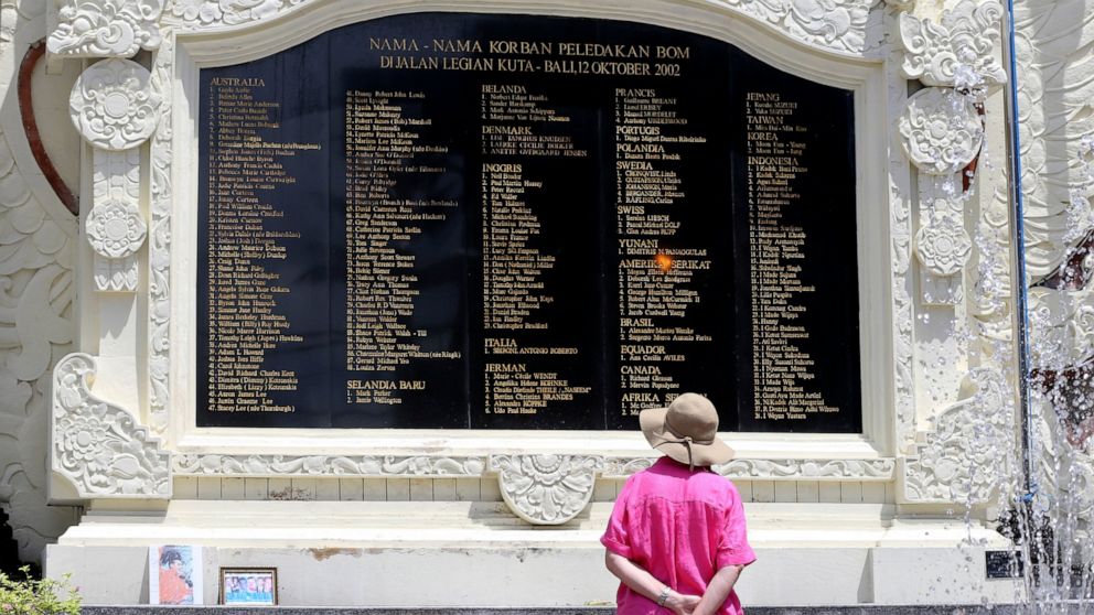A foreign tourist looks at the plaque bearing names of the victims of the Bali bombings at the Bali Bombing Memorial Monument in Kuta, Bali, Indonesia on Thursday, Dec. 8, 2022. An Islamic militant convicted of making the explosives used in the 2002 