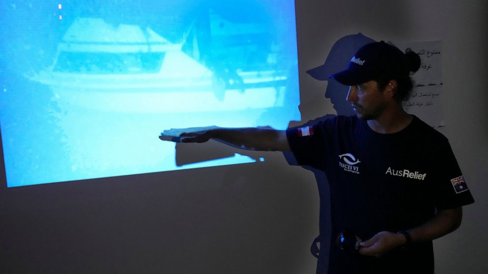 Captain Scott Waters, who drove the small, 3-person underwater craft, a Pisces VI submarine, explains to journalists on a light projector that shows the sank boat during a press conference at the Lebanese navy base, in Tripoli, north Lebanon, Friday,