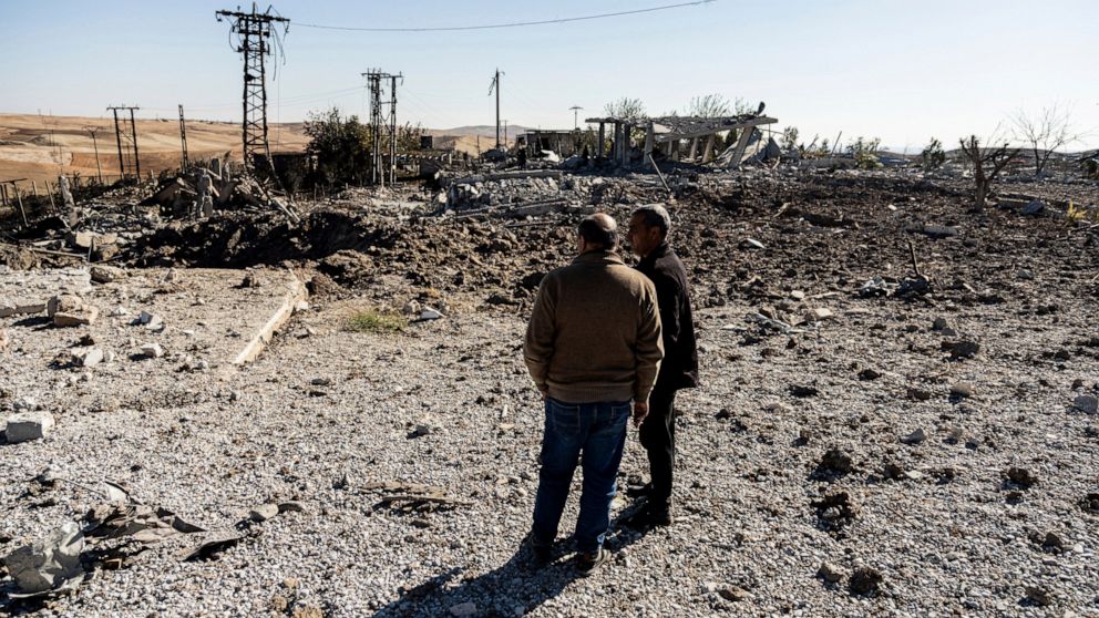 FILE -- People look at a site damaged by Turkish airstrikes that hit an electricity station in the village of Taql Baql, in Hasakeh province, Syria, Sunday, Nov. 20, 2022. Turkish airstrikes on northern Syria over the weekend that killed and wounded 