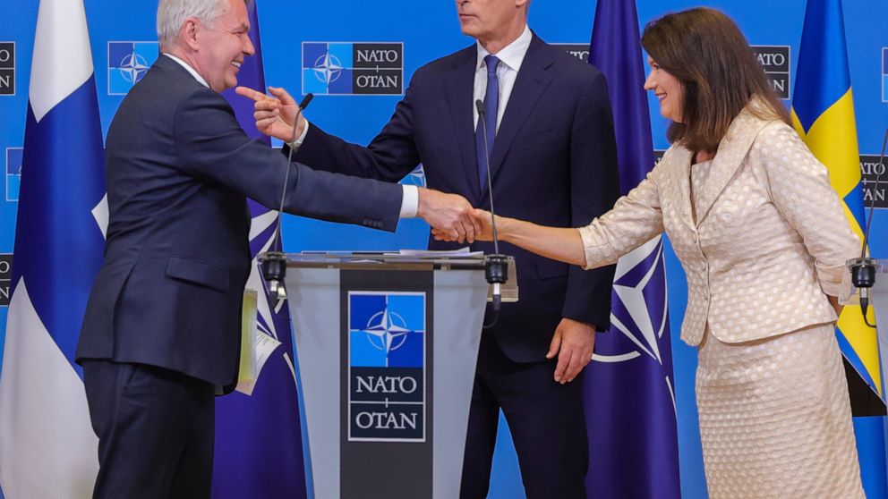 Finland's Foreign Minister Pekka Haavisto, left, Sweden's Foreign Minister Ann Linde, right, and NATO Secretary General Jens Stoltenberg attend a media conference after the signature of the NATO Accession Protocols for Finland and Sweden in the NATO 