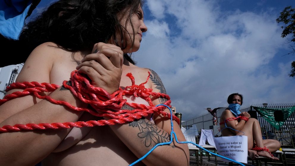 Abortion-rights activists sit gagged and bound as part of a demonstration outside the National Assembly while lawmakers vote on whether to allow abortion in all cases of rape, in Quito, Ecuador, Thursday, Feb. 17, 2022. Currently, abortion is legal i