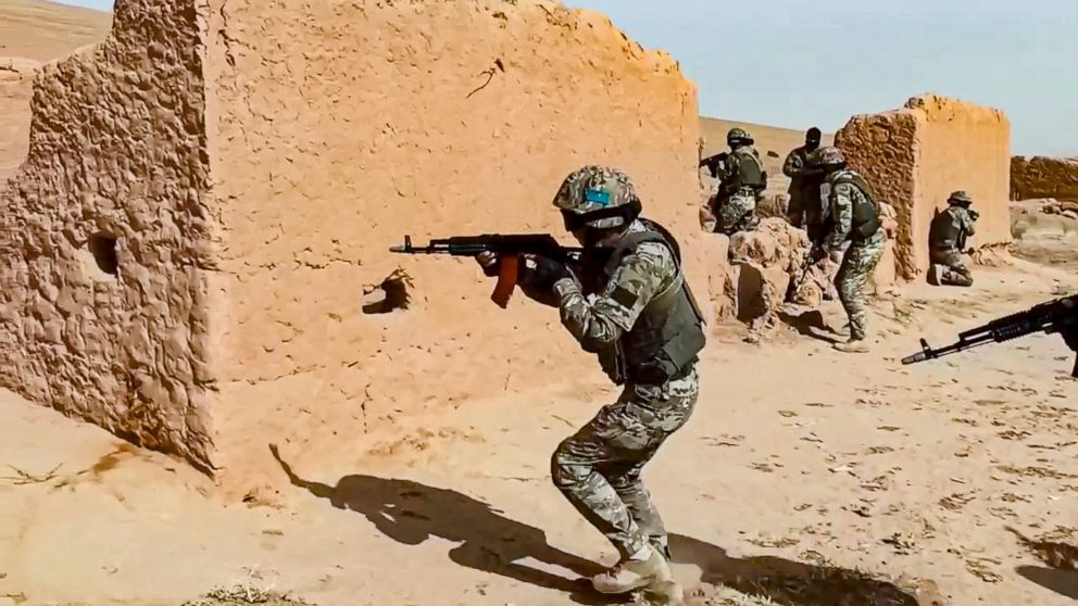 In this handout photo released by Russian Defense Ministry Press Service, Soldiers aim their weapons during joint war games conducted by Russian and Tajik troops at the Momirak firing range about 20 kilometers (about 12 miles) north of the Afghan bor