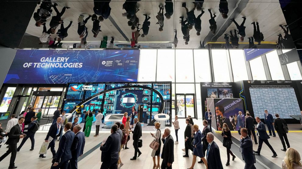 Participants are reflected in the ceiling as they enter a hall at the St. Petersburg International Economic Forum in St.Petersburg, Russia, Wednesday, June 15, 2022. Russia’s annual event to tout its investment opportunities this year was shadowed by