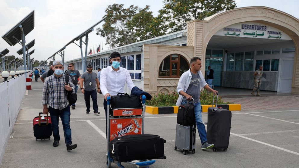 Passengers walk from the domestic terminal at Hamid Karzai International Airport in Kabul, Afghanistan, Saturday, Aug. 14, 2021. As a Taliban offensive encircles the Afghan capital, there's increasingly only one way out for those fleeing the war, and
