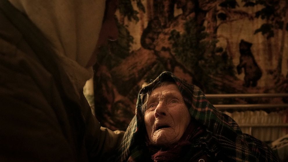 Motria Oleksiienko, 99, traumatized by the Russian occupation, is comforted by daughter-in-law Tetiana Oleksiienko in a room without heating in the village of Andriivka, Ukraine, heavily affected by fighting between Russian and Ukrainian forces, Wedn