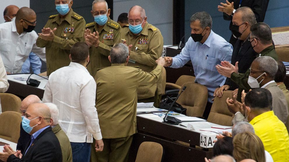 In this photo released by Cubadebate, Gen. Luis Alberto Rodriguez Lopez-Calleja, right, greets former Cuban President Raul Castro at the National Assembly in Havana, Cuba, Dec. 21, 2021. Lopez-Calleja, one of the most trusted advisers to Castro and h