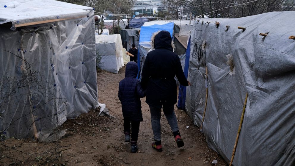 Migrants walk between makeshift tents outside the perimeter of the overcrowded Moria refugee camp after a rainfall on the northeastern Aegean island of Lesbos, Greece, Tuesday, Jan.28, 2020. Greece has been the first point of entry into the European 