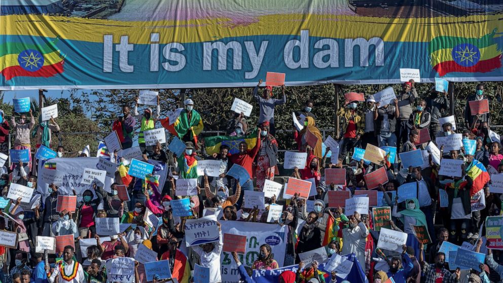 FILE - Ethiopians protest against international pressure on the government over the conflict in Tigray, below a banner referring to The Grand Ethiopian Renaissance Dam, at a demonstration organised by the city mayor's office held at a stadium in the 