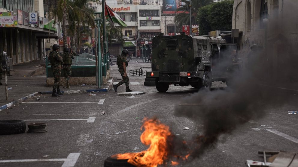 FILE - Palestinian security forces clash with Palestinians following an arrest raid against local militants, in the West Bank city of Nablus Sept. 20, 2022. The rare eruption of deadly clashes this week between Palestinians and their own security for