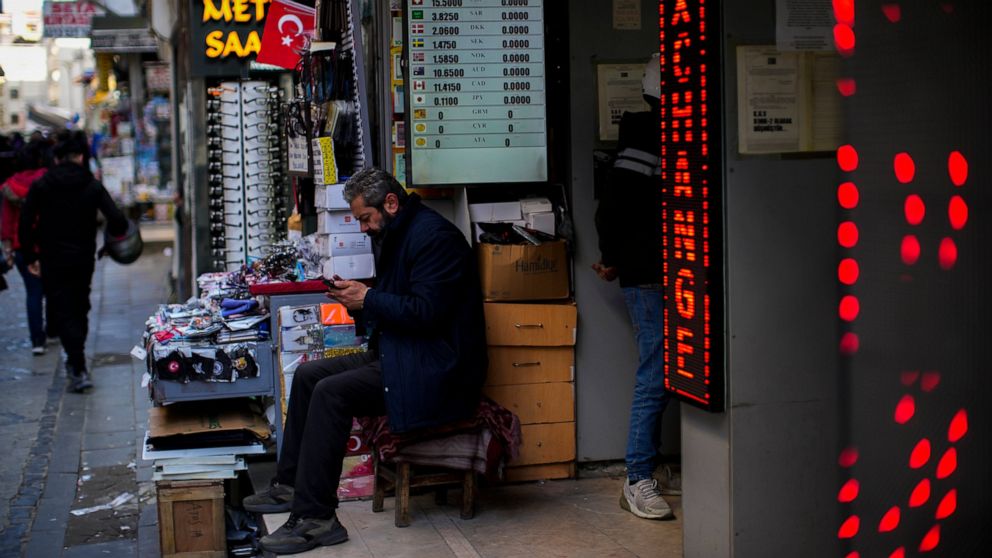 A screen displays exchange rates in a currency exchange shop in a commercial street in Istanbul, Turkey, Thursday, April 14, 2022. Turkey's central bank kept its main interest rate unchanged for a fourth month running on Thursday despite surging infl
