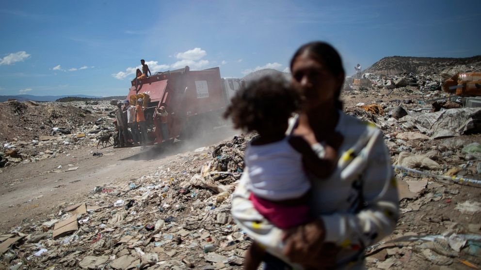 FILE - In this March 3, 2021 file photo, youths who cull through trash for items to resell ride on the back of a garbage truck entering the Pavia landfill on the outskirts of Barquisimeto, Venezuela. A U.S. senator urged the Biden administration Tues