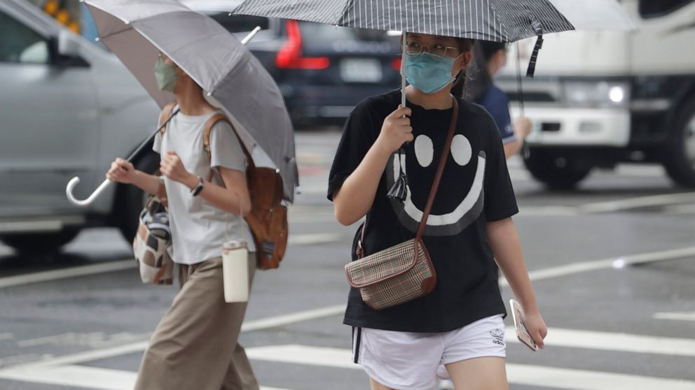 People walk in a rain ahead of the approaching Typhoon Hinnamnor in Taipei, Taiwan, Saturday, Sept. 3, 2022. (AP Photo/Chiang Ying-ying)