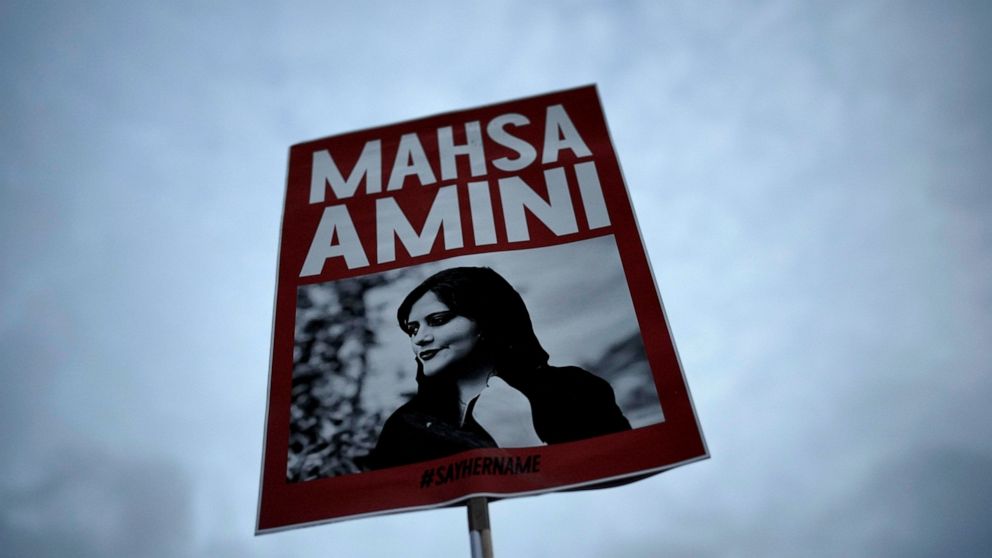 FILE - A woman holds a placard with a picture of Iranian woman Mahsa Amini during a protest against her death, in Berlin, Germany, Wednesday, Sept. 28, 2022. Iranian celebrities have been startlingly public in their support for the massive anti-gover