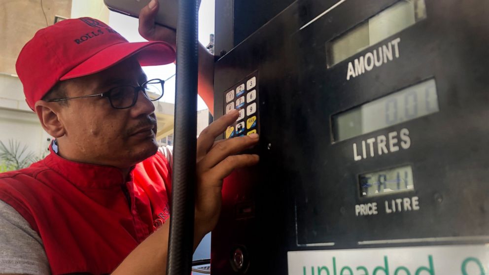 FILE - In this Sept. 22, 2021 file photo, a gas station worker tries to set the new gasoline price after an increase in fuel prices, with most meters unable to accommodate the new five digit price for one liter of gas, in Beirut, Lebanon. Lebanon’s N