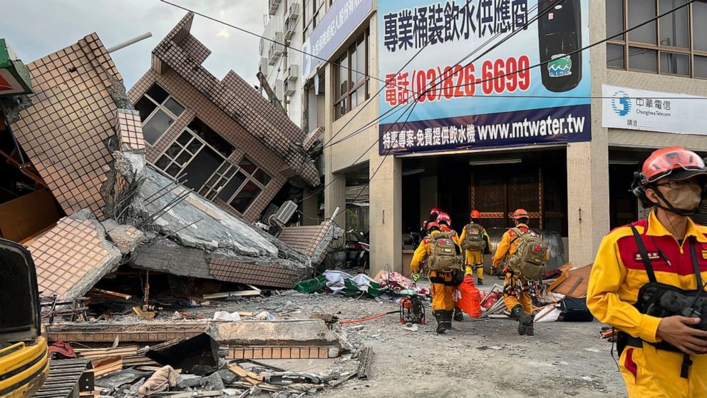 This photo provided by Hualien County fire department show firefighters in the search for trapped victims in a collapsed residential building following earthquake in Yuli township in Hualien County, eastern Taiwan, Sunday, Sept. 18, 2022. A strong ea