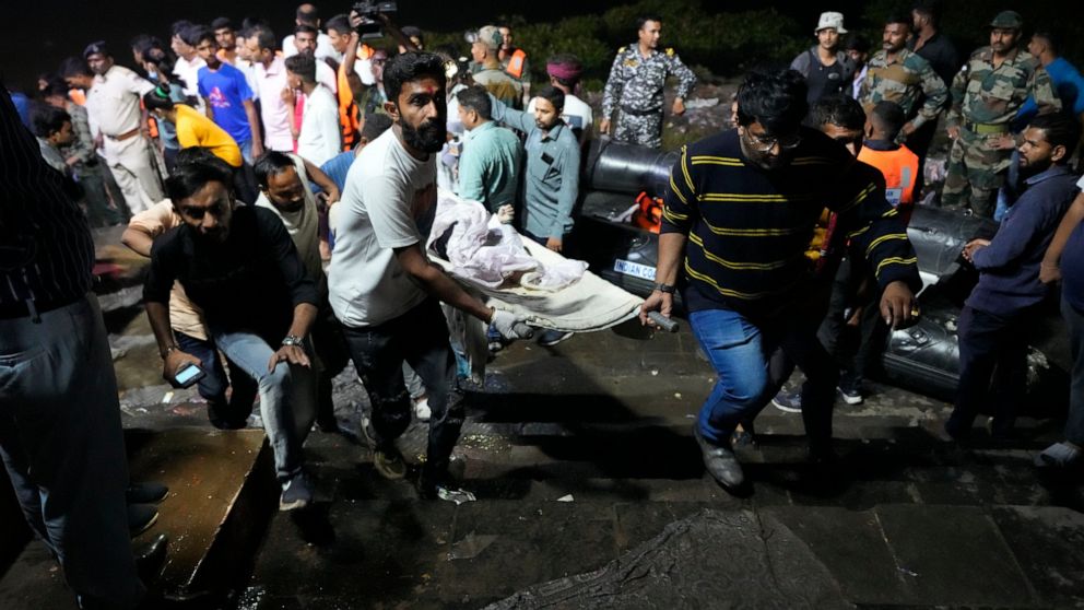 FILE - Volunteers carry a victim after a cable bridge across the Machchu river collapsed in Morbi town of western state Gujarat, India, Monday, Oct. 31, 2022. More than 400 people died in October in a series of crowd-related disasters in Asia that co