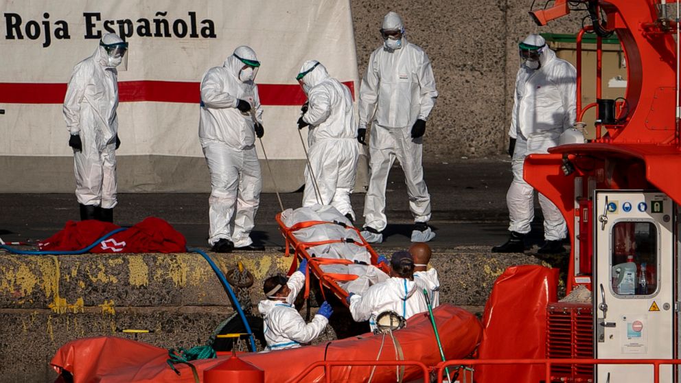 FILE, in this on Friday, Aug. 21, 2020 file photo, emergency workers carry a migrant's body after being found dead by the Spanish Maritime Rescue Service, at the Arguineguin port in Gran Canaria island, Spain. The number of migrants and asylum seeker